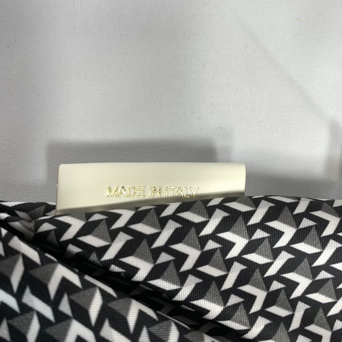 O mini tecido geométrico preto e branco de ROBERTA PIERI com uma etiqueta branca onde se lê "MADE IN ITALY" em letras douradas. O fundo é branco simples.